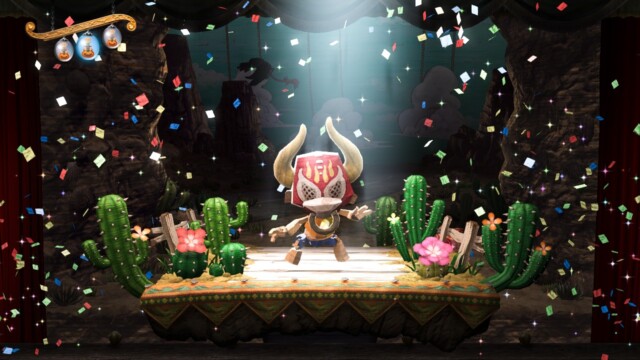 A wooden puppet is centre stage wearing a luchador mask.  There are cacti around him and the stage is covered in confetti. Puppeteer - SCE Japan Studio