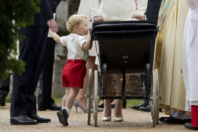 KING'S LYNN, ENGLAND - JULY 05: Catherine, Duchess of Cambridge and Prince William, Duke of Cambridge stand as Prince George of Cambridge looks into Princess Charlotte of Cambridge's pram as they leave the Church of St Mary Magdalene on the Sandringham Estate after the Christening of Princess Charlotte of Cambridge on July 5, 2015 in King's Lynn, England. (Photo by Matt Dunham - WPA Pool/Getty Images)