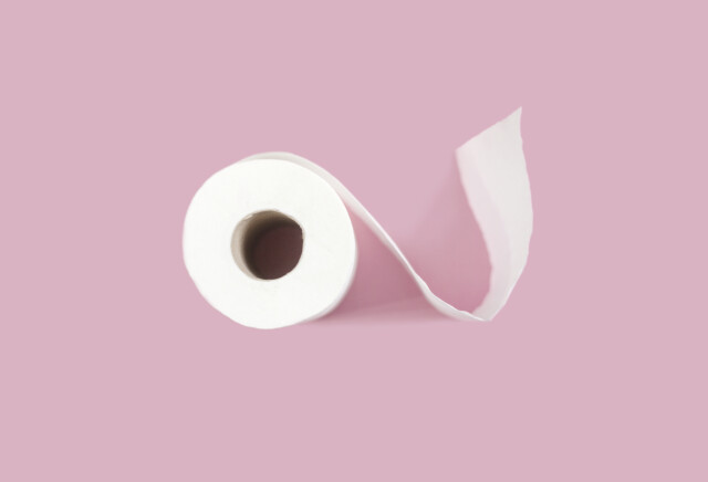 Toilet paper roll on pink background